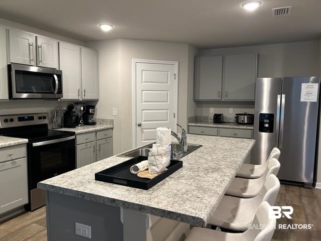 7409 Brompton Drive Foley, AL 36535 - Photo 4 of 18 Kitchen featuring appliances with stainless steel finishes, dark hardwood / wood-style floors, an island with sink, and sink