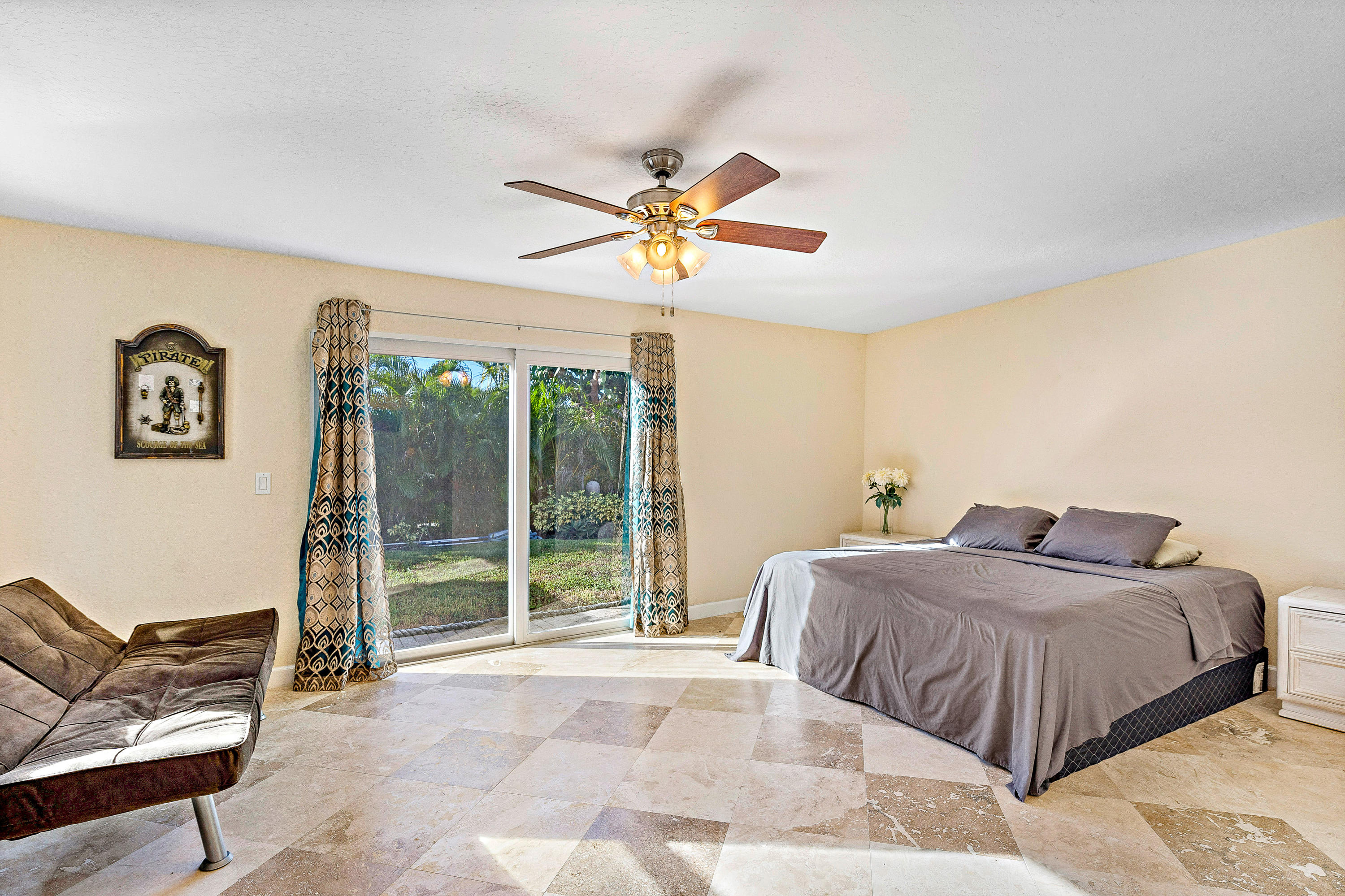 208 Bamboo Road Palm Beach Shores, FL 33404 - Photo 18 of 30 a bedroom with a large bed and a chandelier