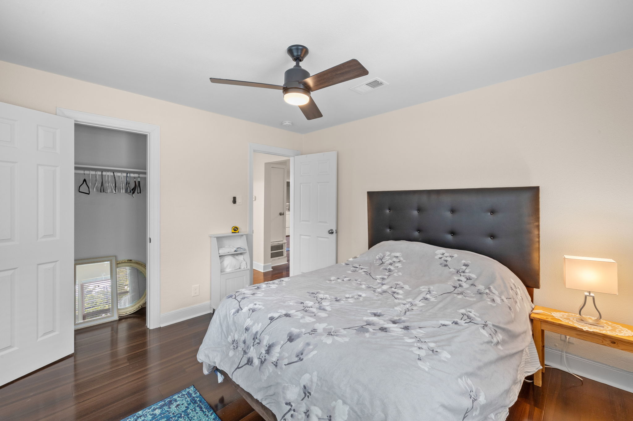 907 East 53rd Street Austin, TX 78751 - Photo 14 of 36 Rich hardwood floors complement this naturally illuminated bedroom, complete with a modern ceiling fan.