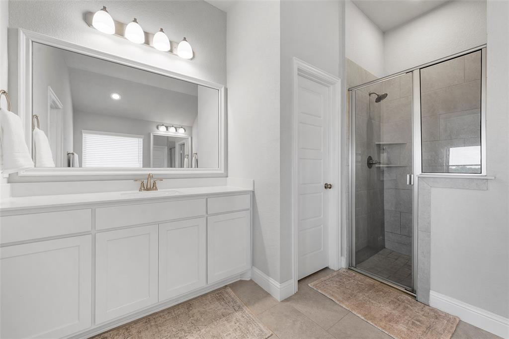 1904 Angelus Street Waco, TX 76712 - Photo 14 of 24 Full bath featuring a stall shower, vanity, and tile patterned flooring