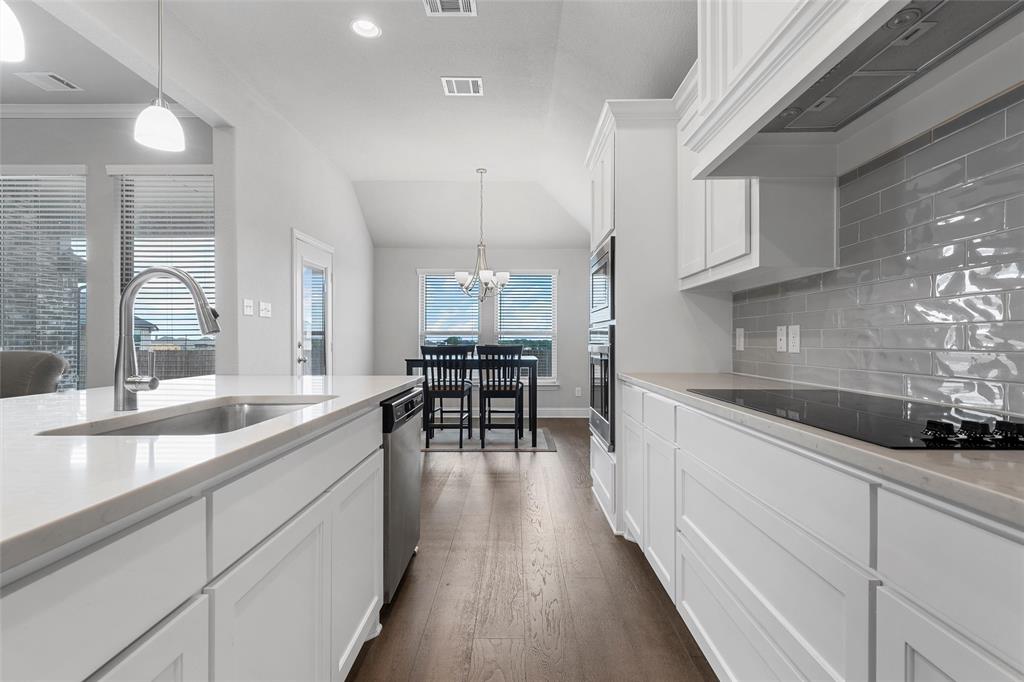 1904 Angelus Street Waco, TX 76712 - Photo 8 of 24 Kitchen with tasteful backsplash, range hood, dark wood-style flooring, white cabinetry, and a chandelier