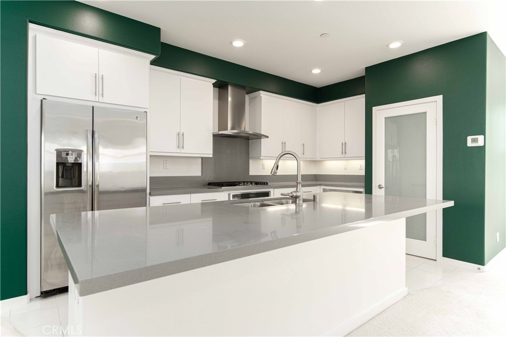 134 Acamar Irvine, CA 92618 - Photo 12 of 56 a large kitchen with stainless steel appliances kitchen island a large counter top a refrigerator and a sink