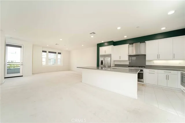 a kitchen with white cabinets and appliances