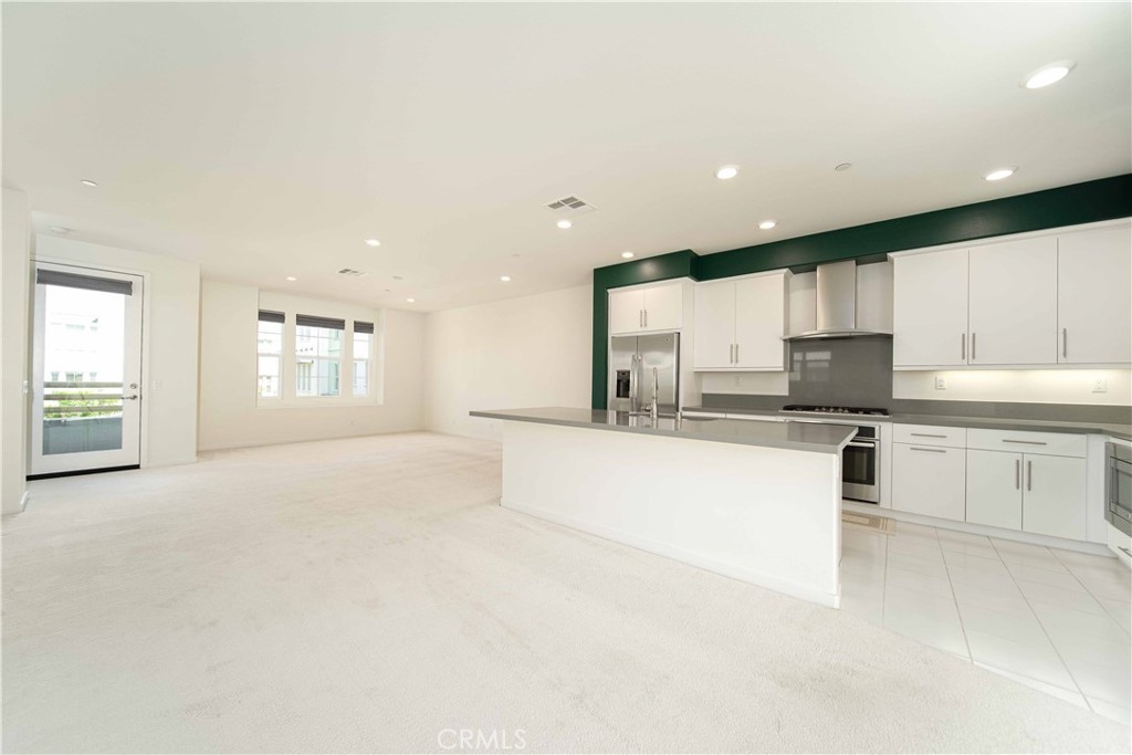 134 Acamar Irvine, CA 92618 - Photo 15 of 56 a large white kitchen with kitchen island a sink white cabinets and stainless steel appliances