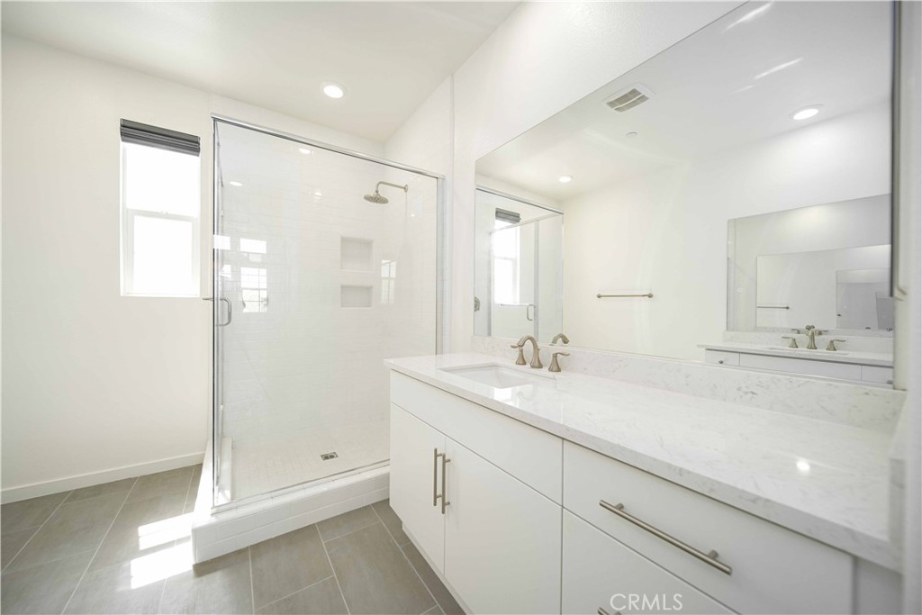134 Acamar Irvine, CA 92618 - Photo 25 of 56 a spacious bathroom with a shower sink and mirror