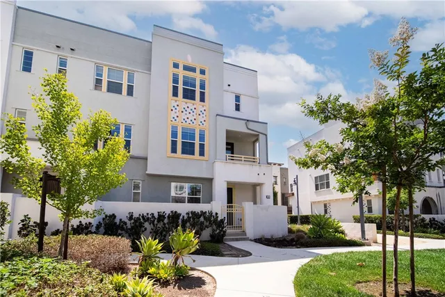a view of a building with potted plants and a yard