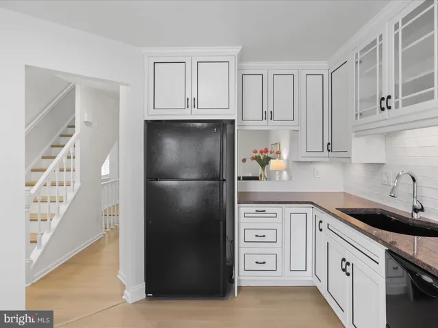 a kitchen with white cabinets and refrigerator