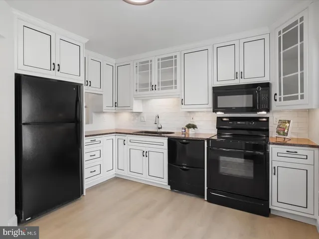 a kitchen with granite countertop white cabinets and stainless steel appliances