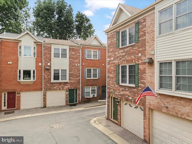 a view of a house with a barbeque and large trees