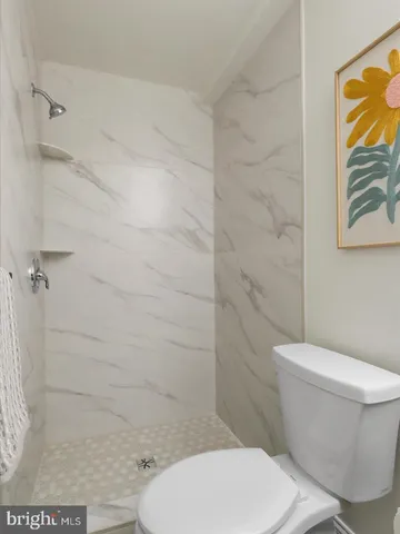 a white toilet sitting next to a bathroom