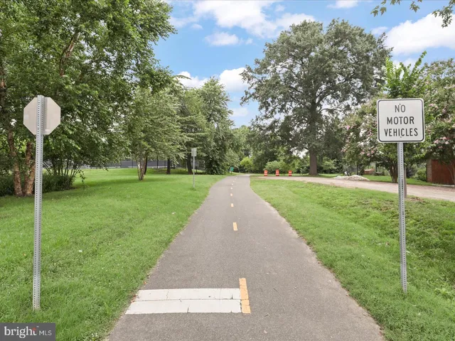 a sign that is sitting in the grass near a tree