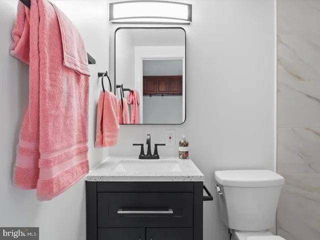 a bathroom with a sink a toilet and a mirror