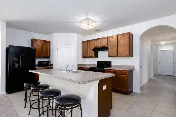 a kitchen with stainless steel appliances granite countertop a sink and a refrigerator