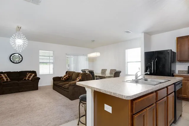 a view of kitchen island a sink wooden floor and windows