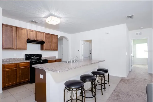 a kitchen with stainless steel appliances a stove a sink island and a refrigerator