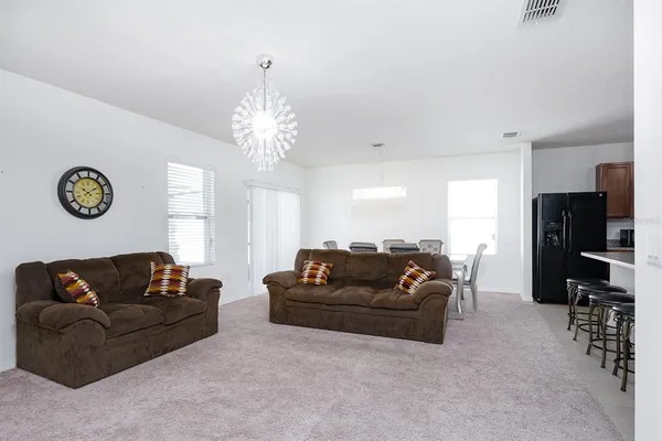 a living room with furniture a flat screen tv and a large window