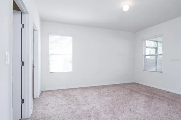an empty room with windows and closet