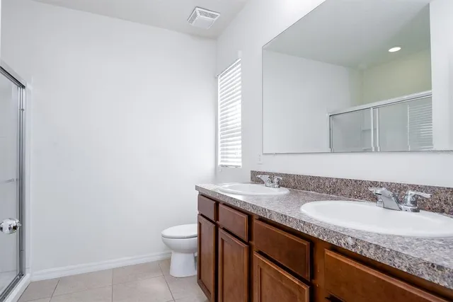 a bathroom with a granite countertop sink a toilet and a mirror