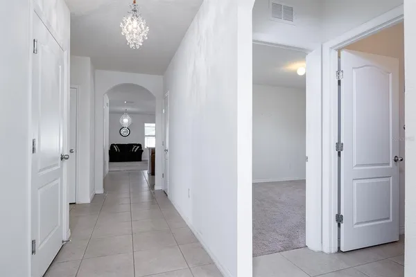 a view of livingroom with hallway and hallway with chandelier