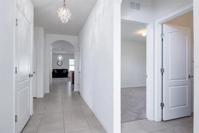 a view of livingroom with hallway and hallway with chandelier