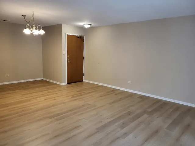 a view of a room with wooden floor and chandelier