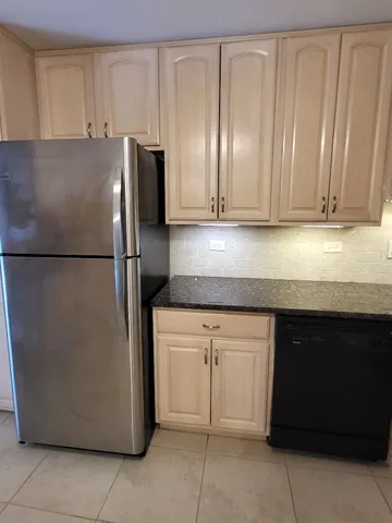 a kitchen with granite countertop a sink dishwasher stove and cabinets with wooden floor