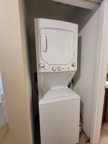 a bathroom with a granite countertop sink toilet a mirror and shower curtain