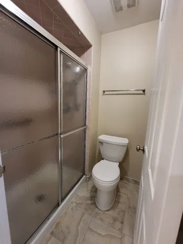 a view of a room with wooden floor and ceiling fan