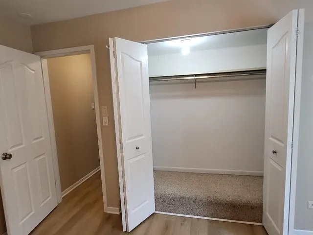 a front view of a building with garage and trees