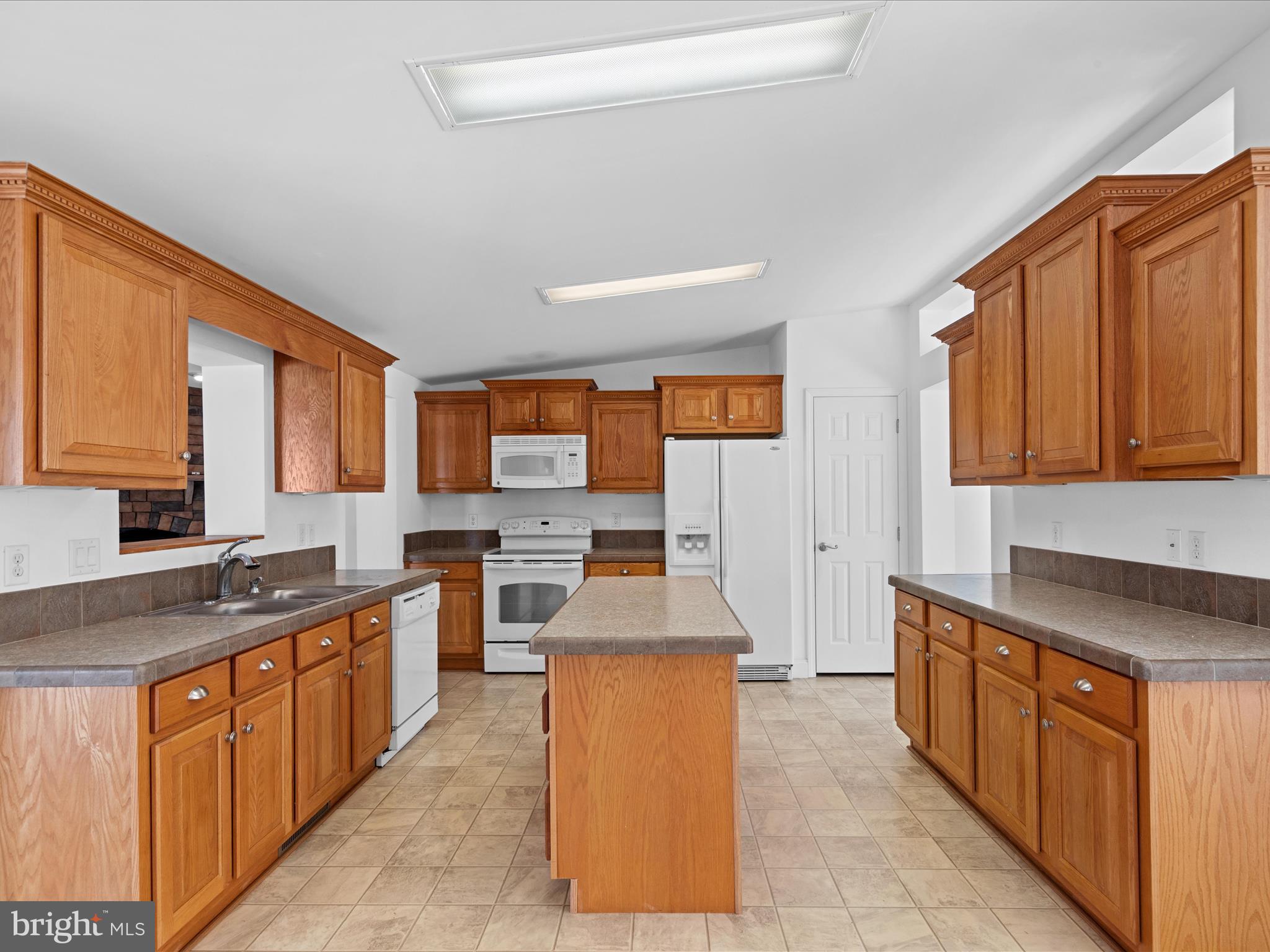 37531 Bonnie Street Ocean View, DE 19970 - Photo 18 of 62 a large kitchen with stainless steel appliances granite countertop a stove a sink dishwasher and a microwave oven with large wooden cabinets