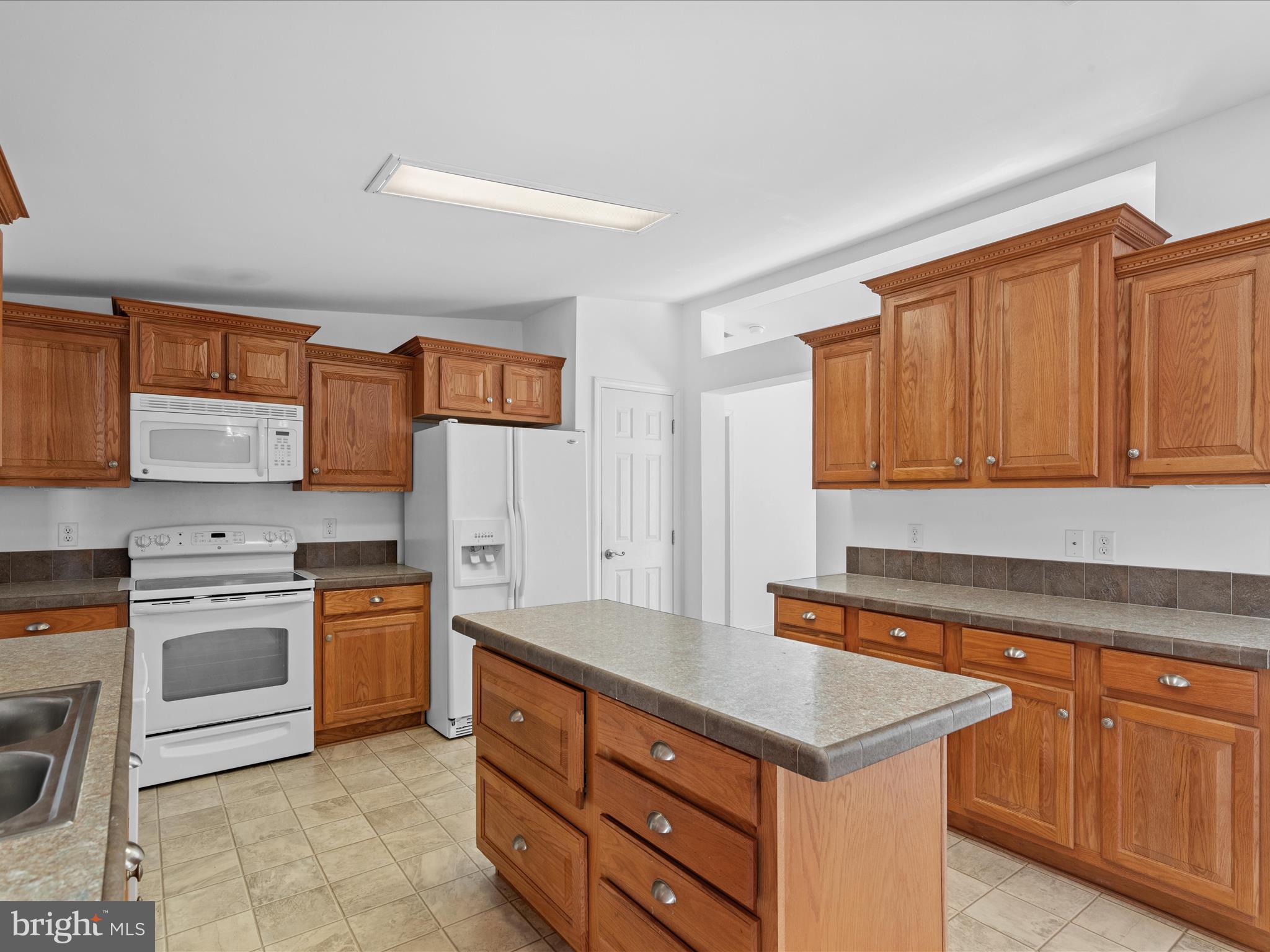 37531 Bonnie Street Ocean View, DE 19970 - Photo 20 of 62 a kitchen with stainless steel appliances granite countertop a stove top oven a sink dishwasher and a refrigerator with wooden cabinets