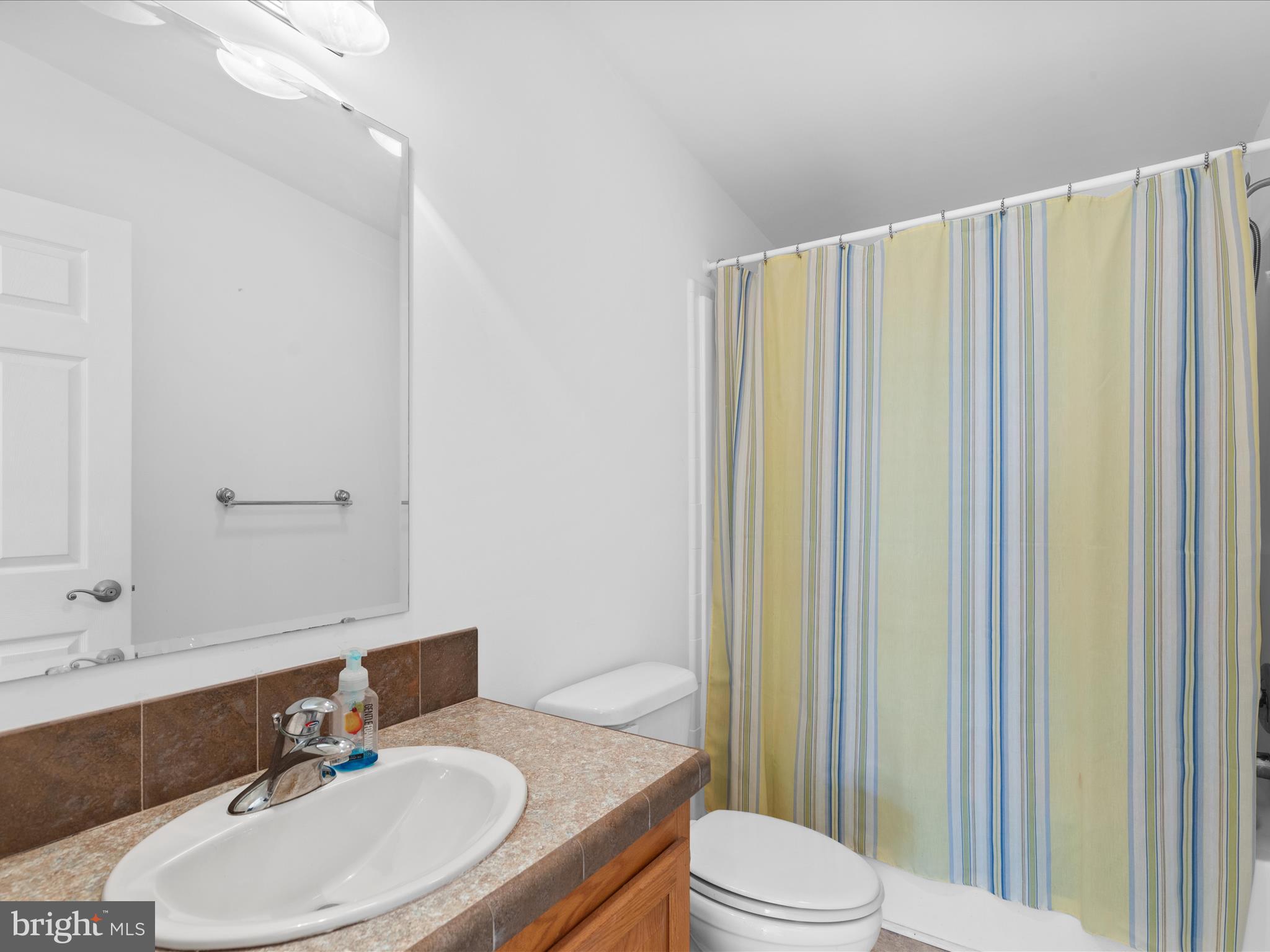 37531 Bonnie Street Ocean View, DE 19970 - Photo 33 of 62 a bathroom with a sink a toilet and shower curtain