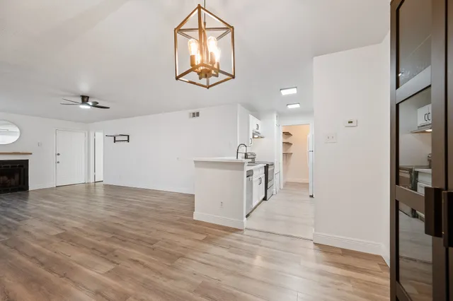 a view of an empty room with wooden floor