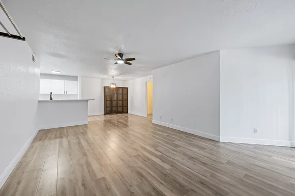 a view of empty room with wooden floor and fireplace