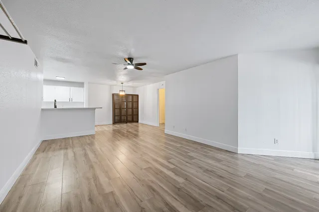 a view of empty room with wooden floor and fireplace