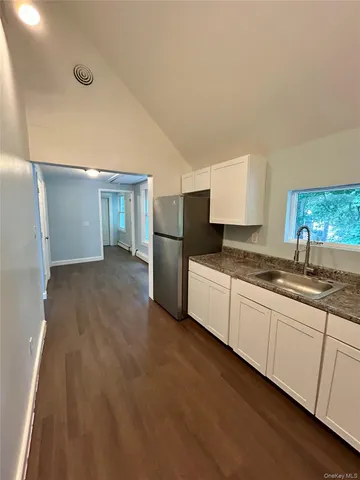 a kitchen with granite countertop a refrigerator and a sink
