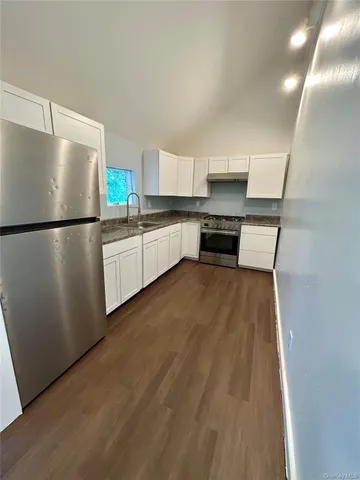 a kitchen with stainless steel appliances a refrigerator and a stove top oven