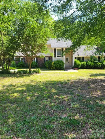 a view of a house with a yard and trees