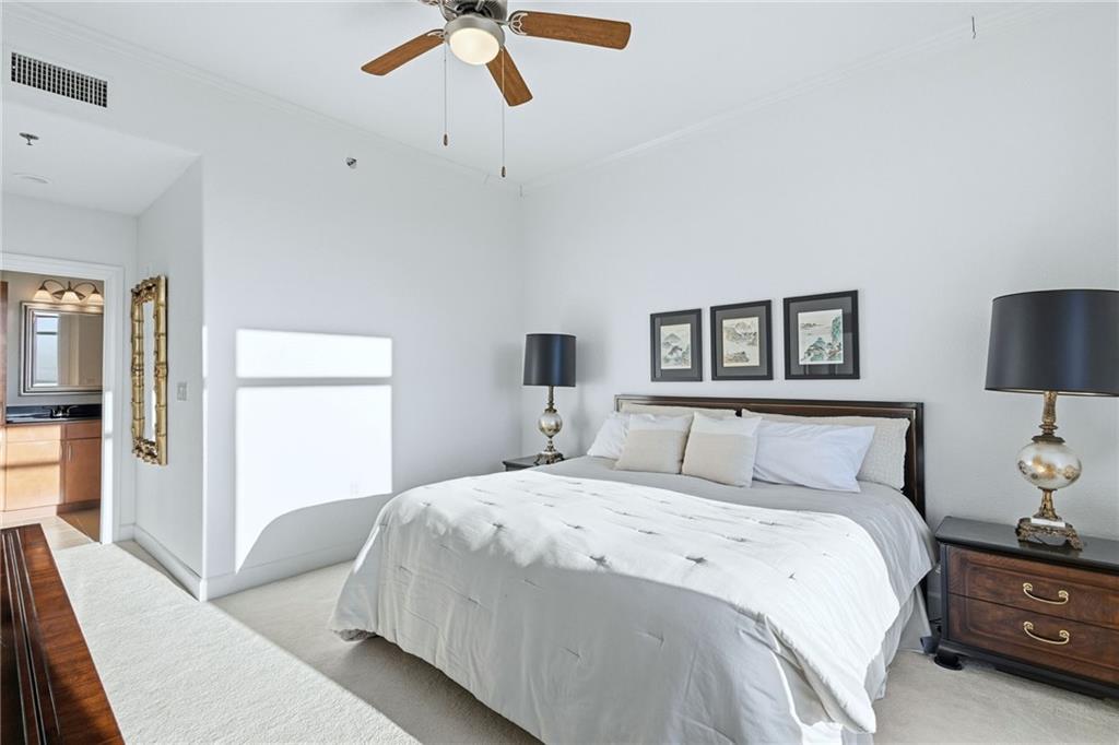 3445 Stratford Road Northeast, Unit 3601 Atlanta, GA 30326 - Photo 12 of 37 a bedroom with a large bed and a chandelier