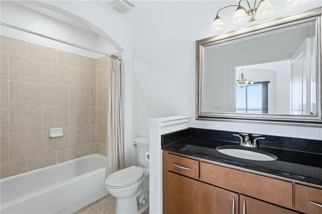 3445 Stratford Road Northeast, Unit 3601 Atlanta, GA 30326 - Photo 9 of 37 a bathroom with a granite countertop sink a toilet a mirror a bathtub and shower