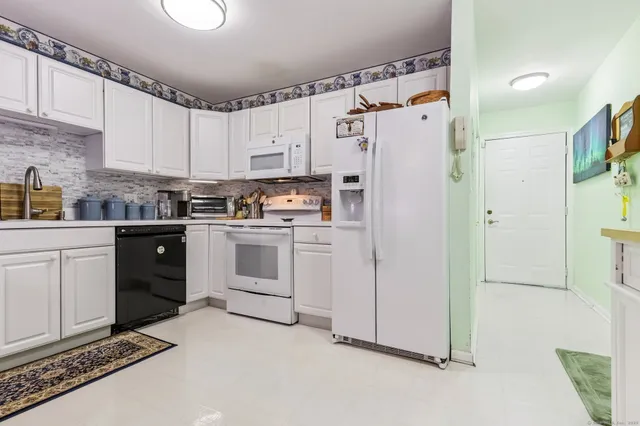 a kitchen with white cabinets and white appliances