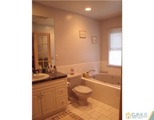 4 Regal Road Edison, NJ 08820 - Photo 8 of 10 a bathroom with a granite countertop sink a toilet a mirror and bathtub