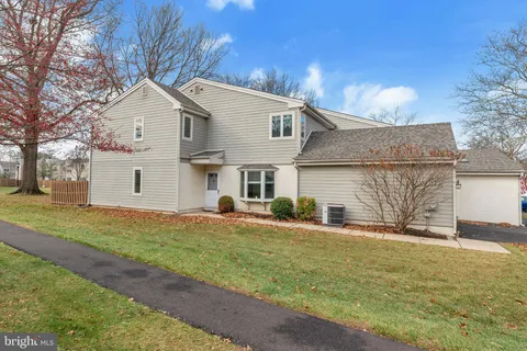a view of a yard in front of a house with large tree