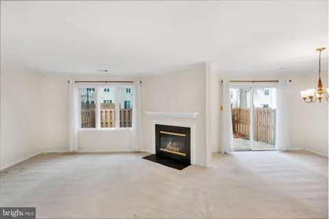 an empty room with windows and fireplace