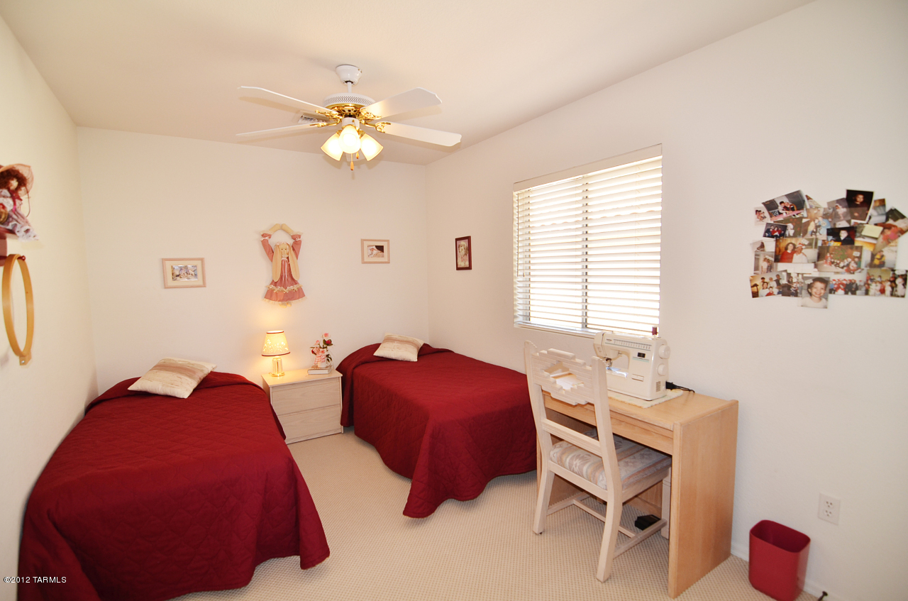 1330 East Crown Ridge Drive Tucson, AZ 85755 - Photo 14 of 22 a bedroom with a bed and a chandelier