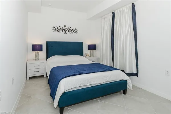 a large bed sitting in a bedroom next to a cabinet