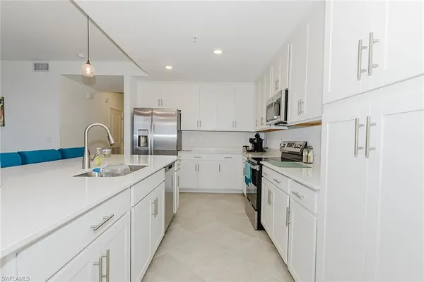 a kitchen with white cabinets appliances and sink