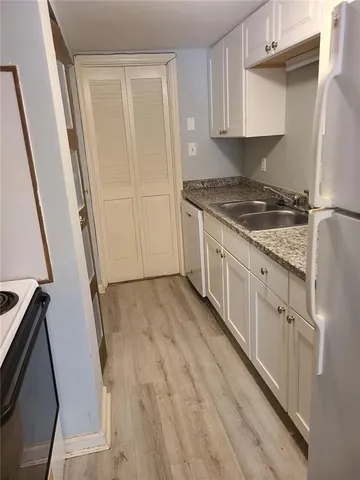 a kitchen with granite countertop a sink a stove oven and cabinets