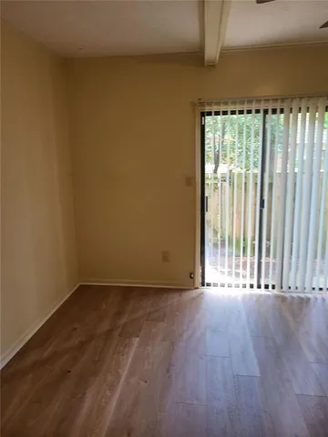 a view of a room with wooden floor and a window
