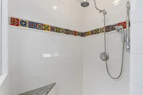 a bathroom with a shower a glass door shower and a shower head